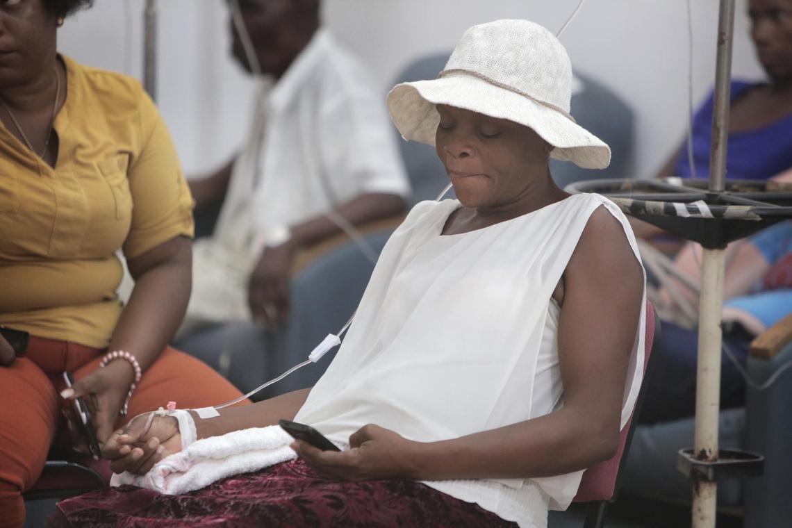 Port-au-Prince, August 8, 2018 - Gerda Janvier (center), 46 yrs old, a cervical cancer patient from La Plaine, Haiti sits in the chemotherapy treatment room along with other patients at Innovating Health International (IHI) in Port-au-Prince as she gets fluids intravenously. Because her blood count was low, she could not get her chemotherapy treatment that day.