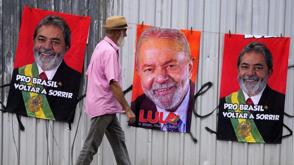A man in Brasilia, Brazil, walks past images of former President Lula da Silva, who is seeking the office again.