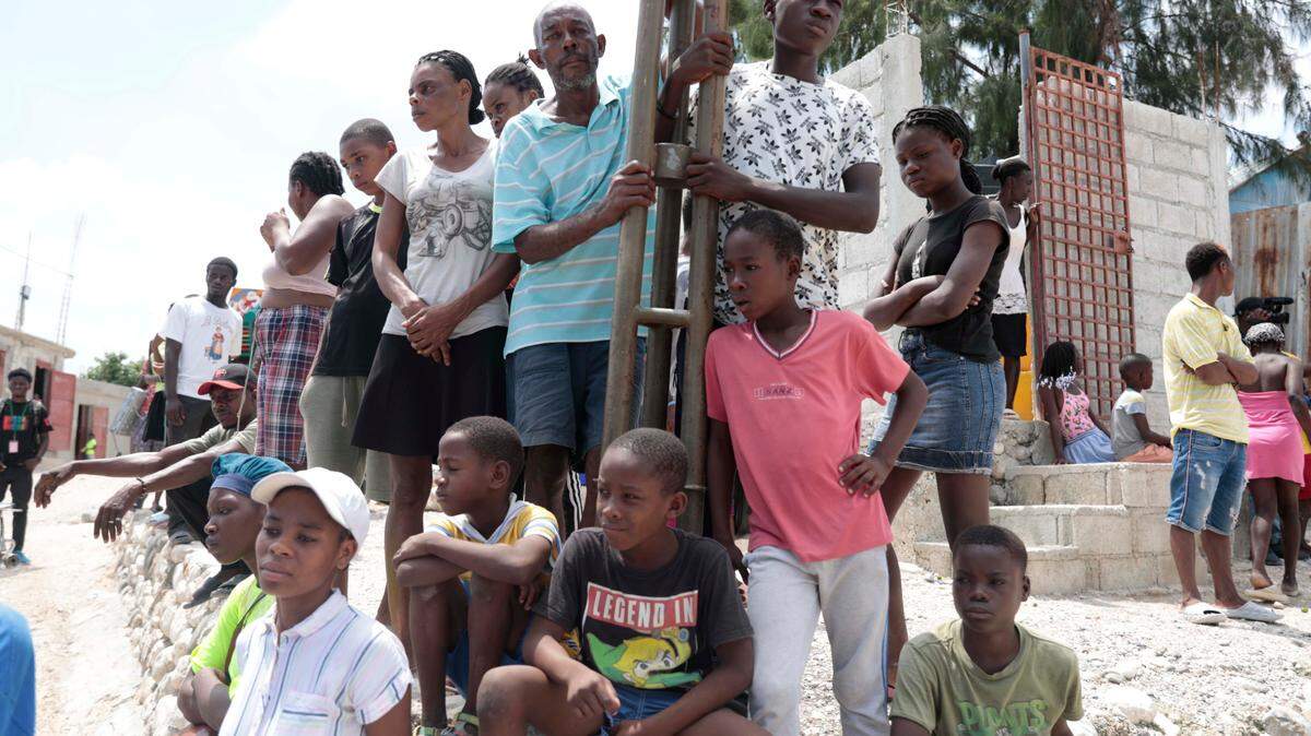 A crowd gathered Sunday in Haiti, a day after members of a criminal gang shot and killed churchgoers marching on the outskirts of Port-au-Prince in opposition to the gang.