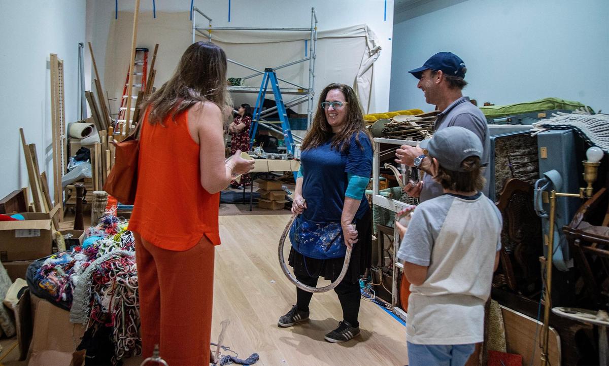 Artist Kerry Phillips gives a tour to Leon Benoit Hurs and his parents Cecilia Garcia-Hurs and Pablo Hurs of Texas, through items she has collected through the years as she engages visitors to observe and engage with her as she builds the installation of the piece for her coming solo exhibit titled “Kerry Phillips: Between the Mundane and the Miraculous.” at the Bass Museum in Miami Beach opening August 17th. on Friday, August 04, 2023.