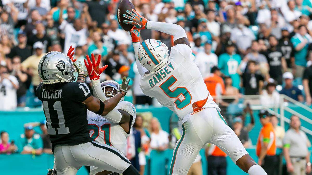 Miami Dolphins cornerback Jalen Ramsey (5) intercepts the ball from Las Vegas Raiders wide receiver Tre Tucker (11) in the fourth quarter of an NFL game at Hard Rock Stadium on Sunday, Nov. 19, 2023, in Miami Gardens, Fla.