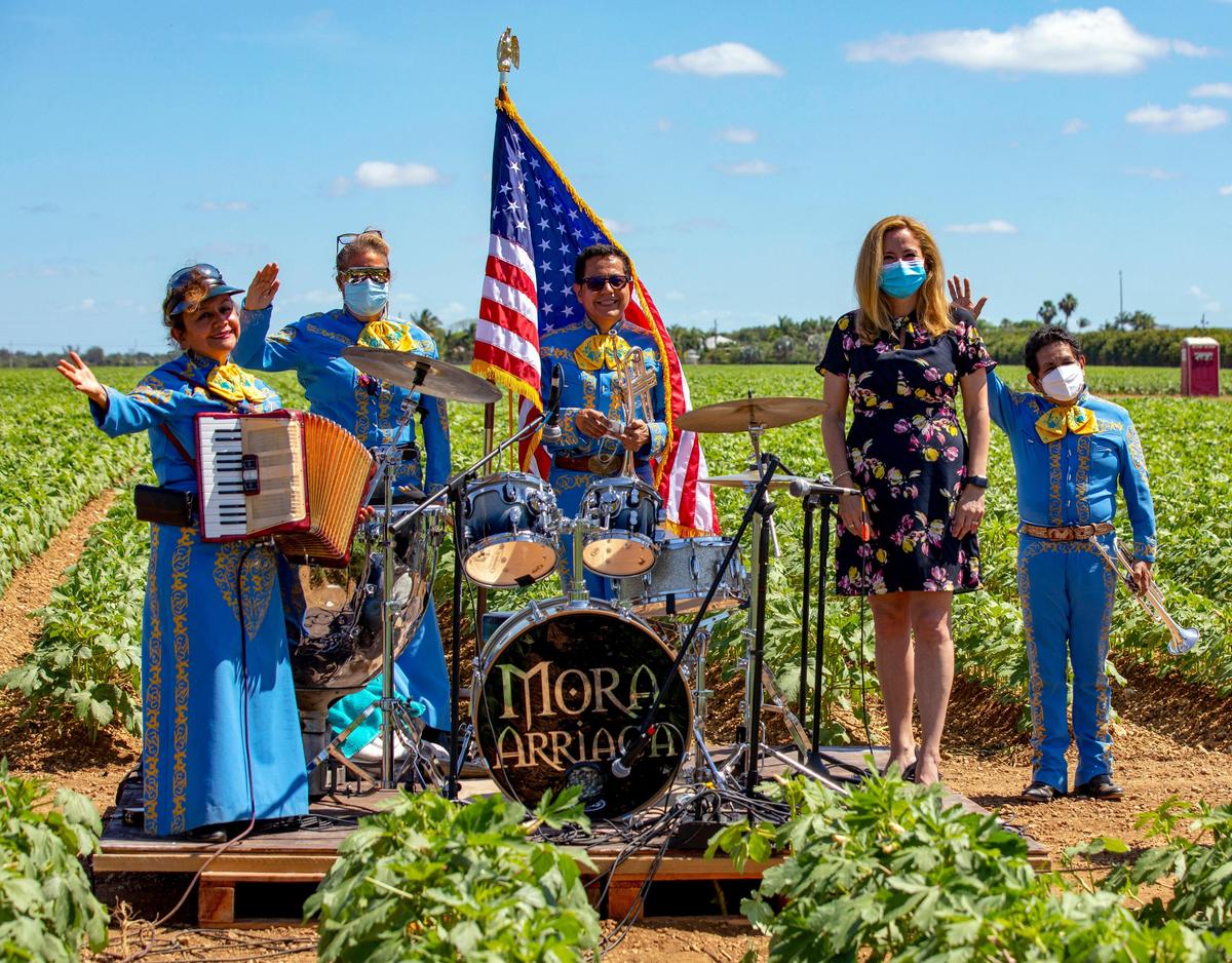 Congresswoman Debbie Mucarsel-Powell stands with instructors from the Homestead-Miami Mariachi Conservatory during a Cinco de Mayo celebration at Sifuentes Farms in Homestead, Florida on Tuesday, May 5, 2020.