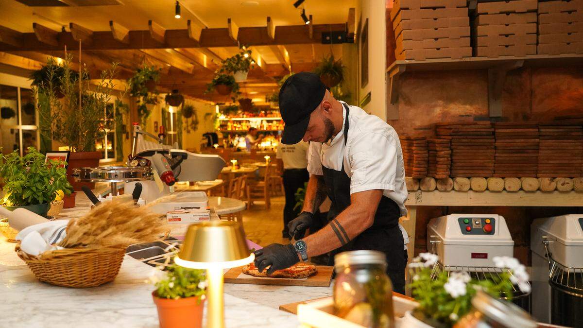 A chef cuts a pizza at the new Gaby by Call Me Gaby in Aventura.