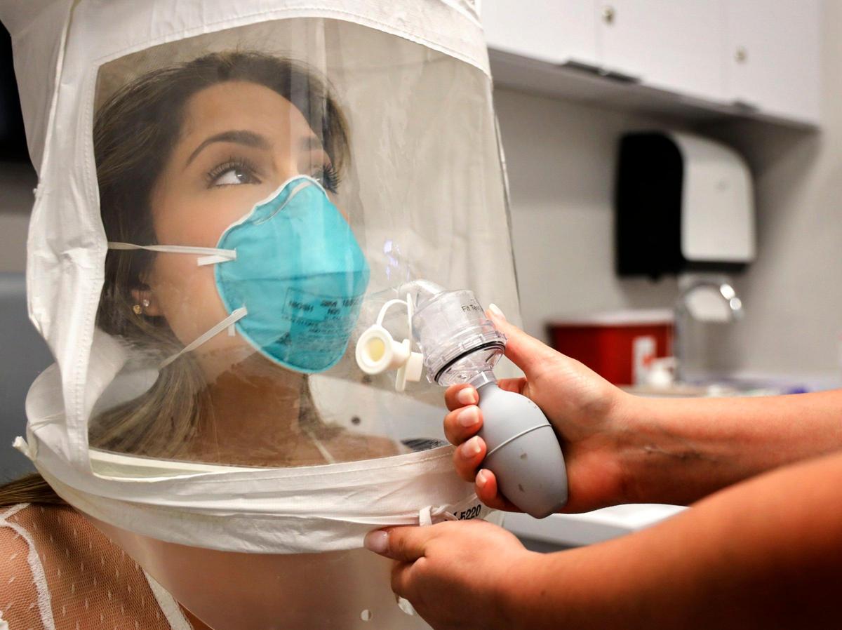 Emergency room RN Erika Juvier, 24, gets fitted with a particulate respirator and surgical mask with a hood to make sure that the mask fits properly on her face during the test at Nicklaus Children’s Hospital’s employee headquarters on Thursday, March 5, 2020 in Miami, Florida.