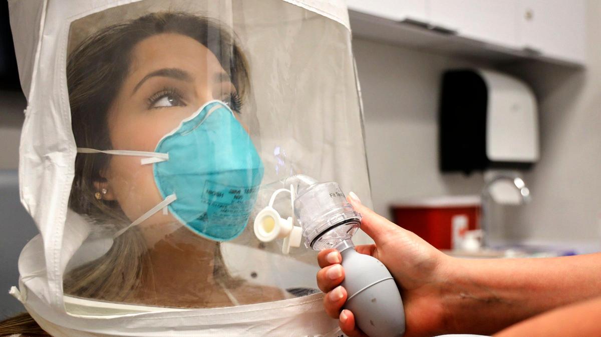 Emergency room RN Erika Juvier, 24, gets fitted with a particulate respirator and surgical mask with a hood to make sure that the mask fits properly on her face during the test at Nicklaus Children’s Hospital’s employee headquarters on Thursday, March 5, 2020 in Miami, Florida.