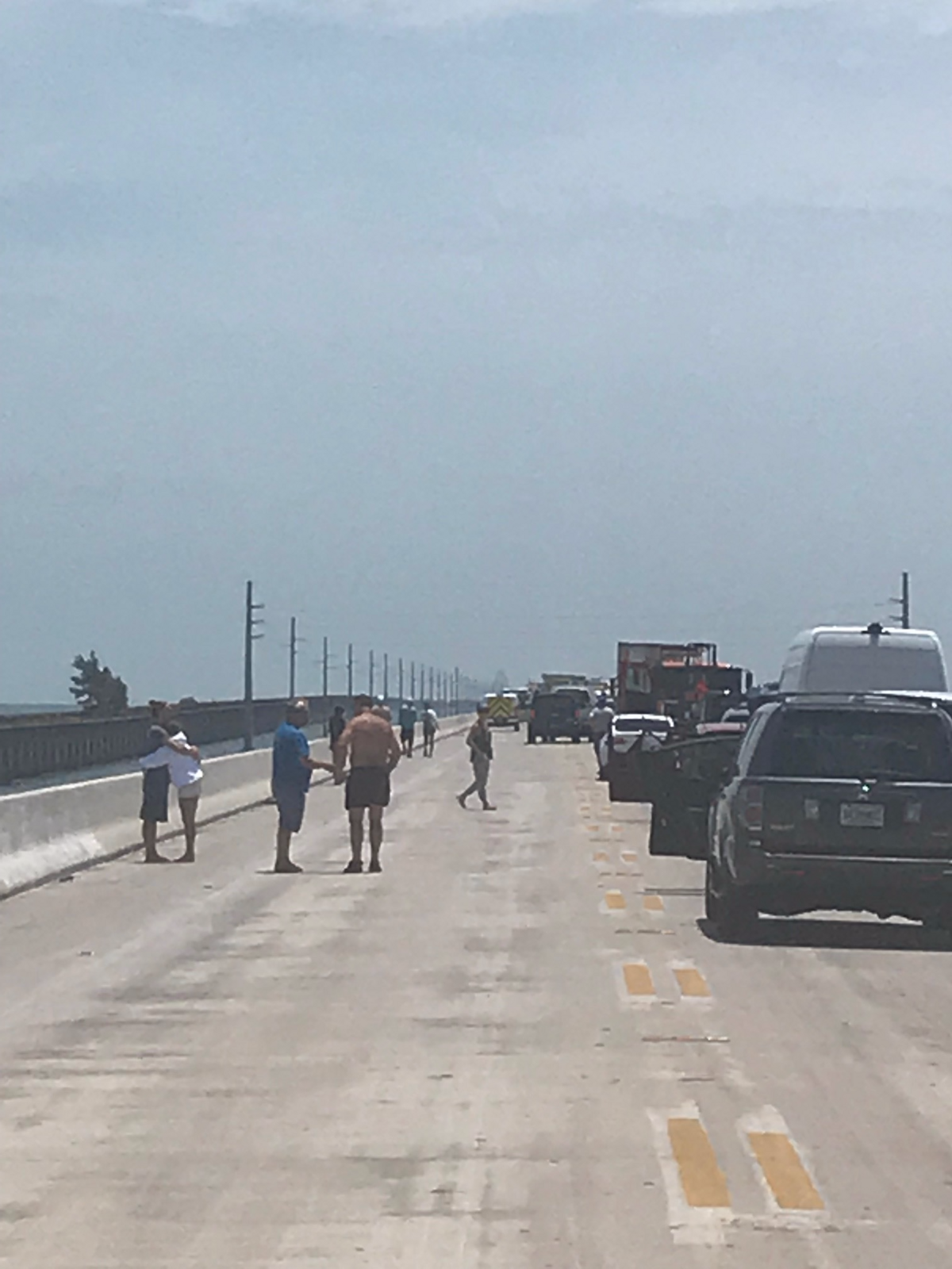 People get out of their vehicles on the south end of the Seven Mile Bridge Monday afternoon, July 23, 2018, after a head-on collision that injured five people.