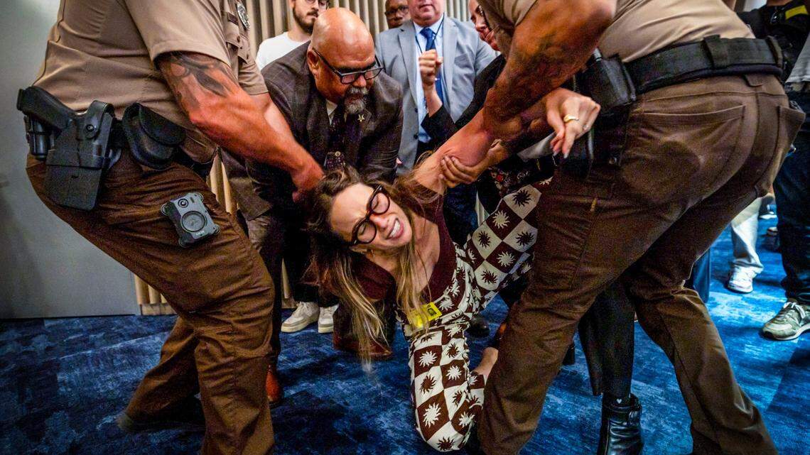 Camila Ramos is forcibly removed from the commission chambers by officers during a Miami-Dade County Commission meeting at the Stephen Clark Center on Thursday, June 26, 2025, in Miami, Fla.