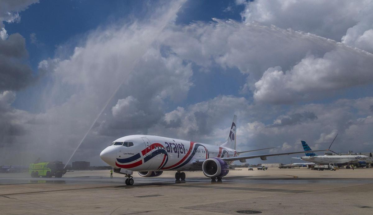 An Arajet plane gets a water cannon salute as it arrives in Miami on Friday April 11, 2025.