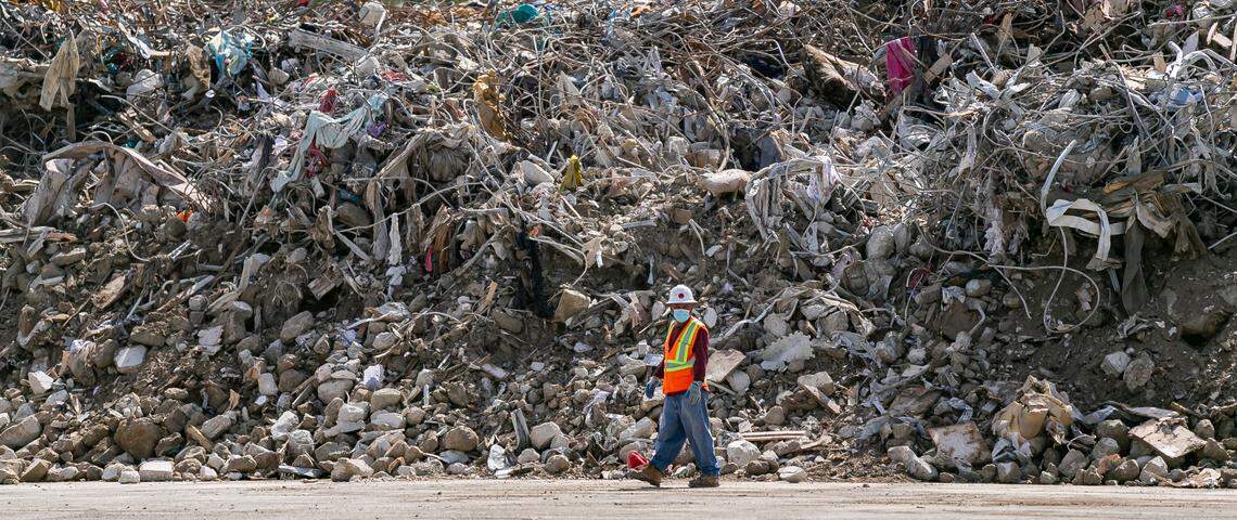 Large piles of debris and rubble from the collapsed Champlain Towers South can be seen inside a lot near the Miami International Airport at the intersection of Milam Dairy Road and Northwest 12th Street in Miami, Florida, on Saturday, July 10, 2021.