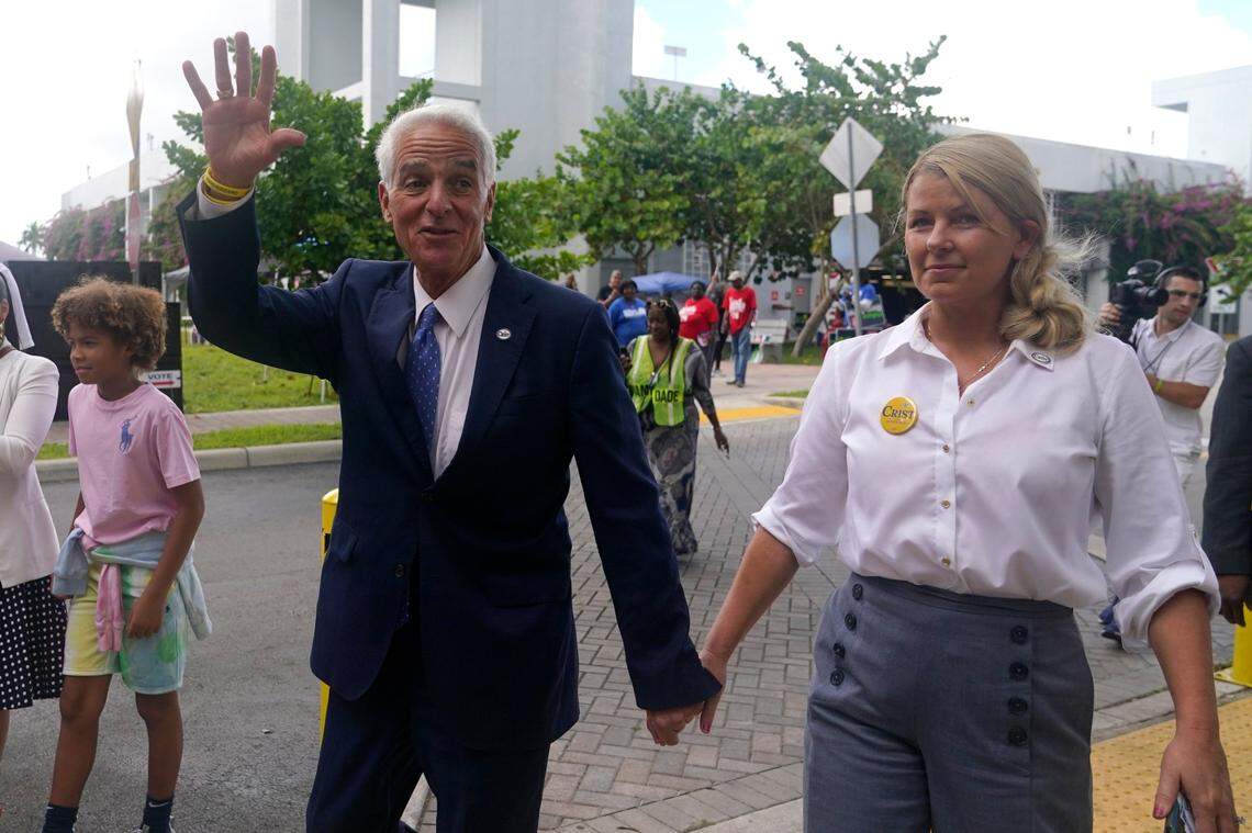 Democratic candidate for Florida governor Charlie Crist, left, waves as he arrives with his fiancee, Chelsea Grimes, right, as he campaigns at an early voting location, Sunday, Nov. 6, 2022, in Miami.