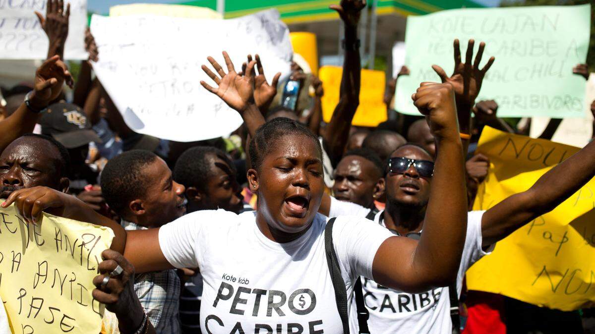 A woman wears a t-shirt with text written in Creole that reads, “Where are the PetroCaribe Funds?” while chanting anti-government slogans during a protest in front of the Superior Court of Accounts and Administrative Litigation, to demand an accounting of the Petrocaribe funds, in Port-au-Prince, Haiti, on Friday, Aug. 24, 2018.