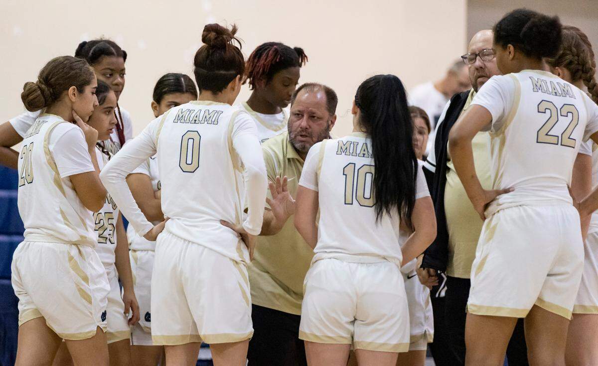 Miami Senior High School Lady Stings coach Sam “Boozer” Baumgarten, center, talks to his players during the first period of their basketball game against the Miami Palmetto Senior High School Lady Panthers at Miami Senior High School on Friday, Feb. 3, 2023, in Miami, Fla.