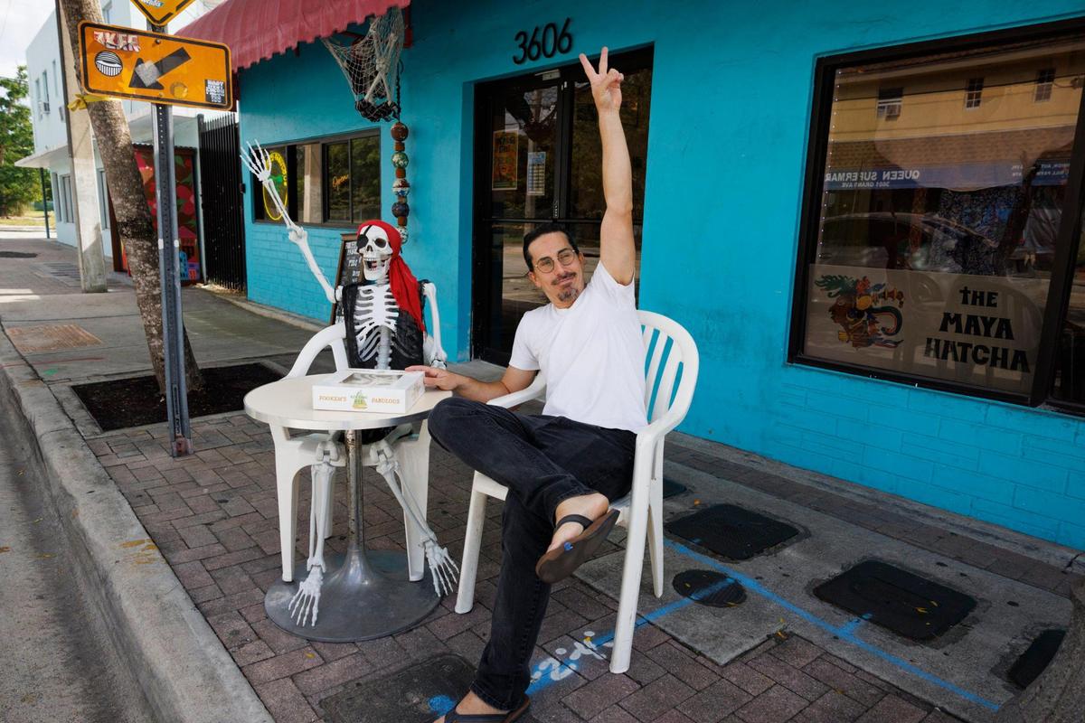 Joshua Abril waves to passersby at his new pie shop in Coconut Grove.