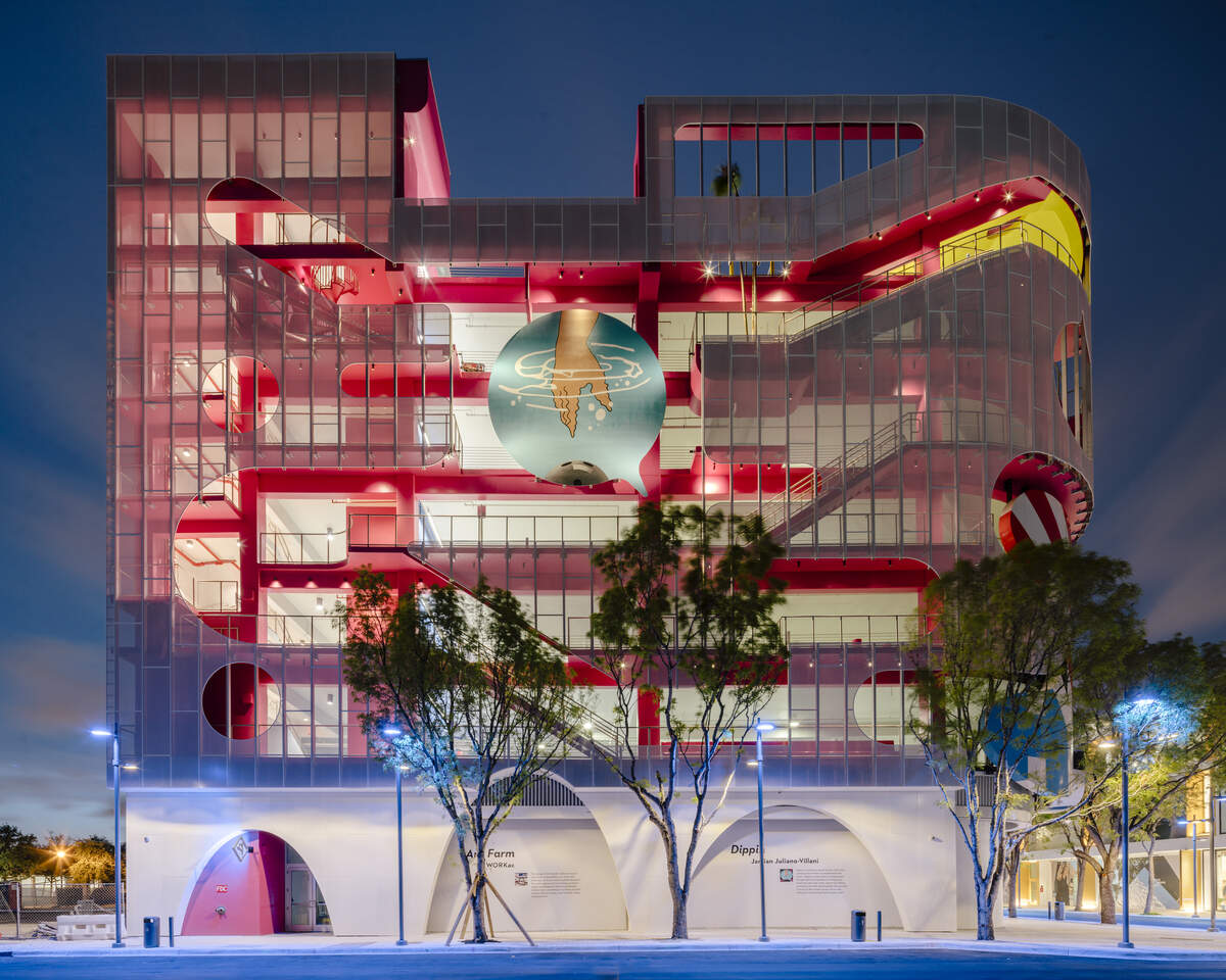 The Museum Garage's "Ant Farm" facade, by architects WORKac. of New York, consists of stairways and public spaces such as a library, a playground, a DJ booth and an art gallery. At the center of the facade is a circular mural, "Dippin," by New York artist Jamien Juliano-Villani, depicting a hand reaching for a bowling ball that's under water.
