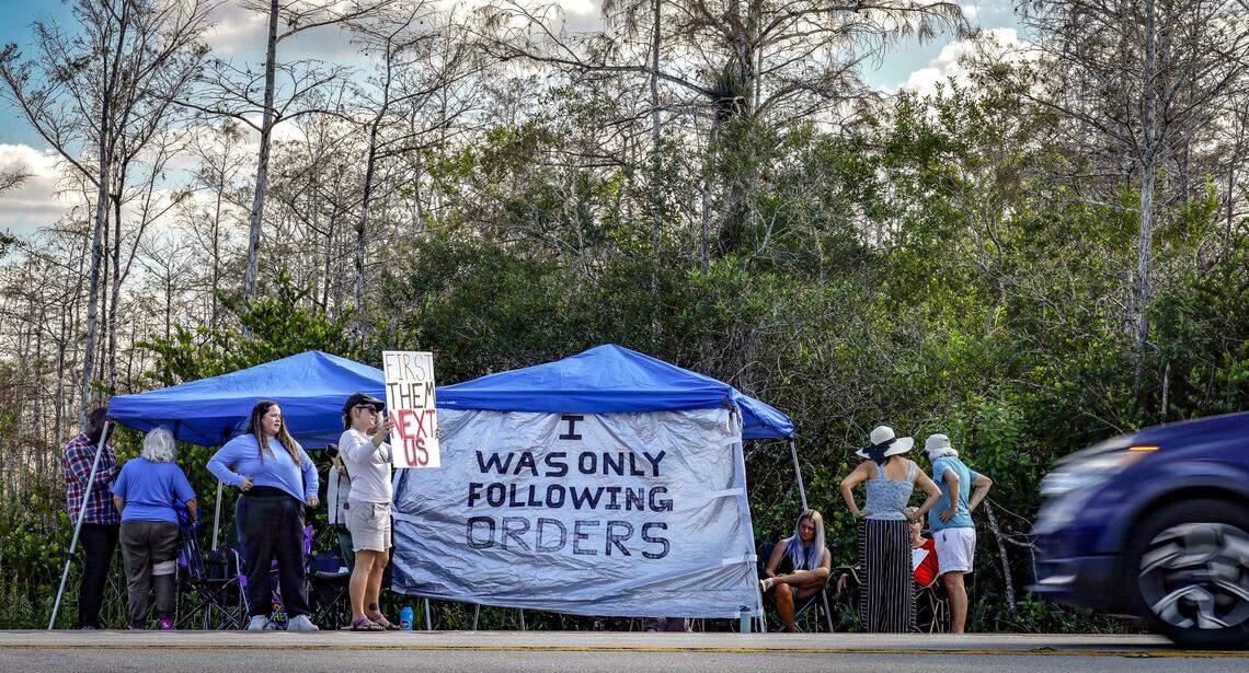Protestors gather at their tents across the street from the entrance to Alligator Alcatraz along Tamiami Trail on Wednesday, November 19, 2025. They have been camping all day outside of the immigration detention facility since it's opening. Alligator Alcatraz is located at Dade-Collier Training and Transition Airport inside Big Cypress National Preserve in Ochopee, Florida.