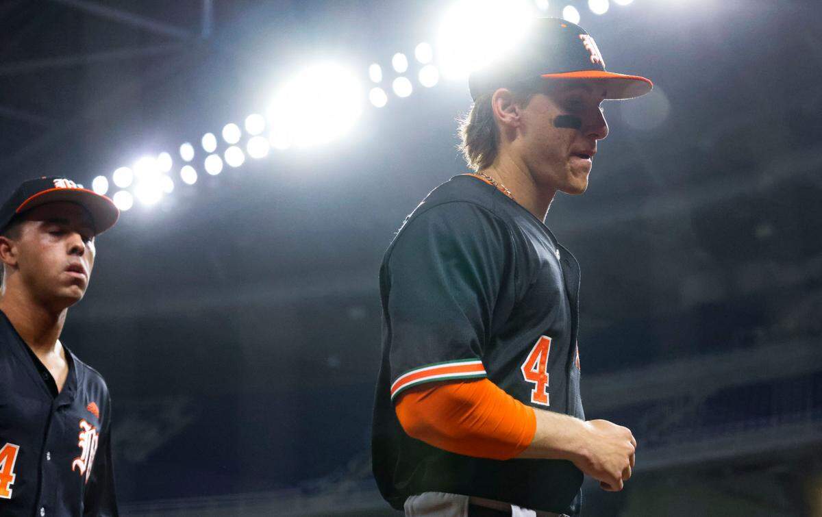 Miami shortstop Jake Ogden (4) and third baseman Daniel Cuvet (14) come into the dugout after the first inning of a game on Tuesday, March 4, 2025, at loanDepot Park in Miami, Fla.