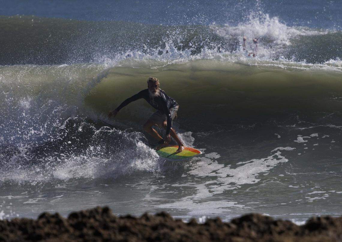 Lance, a surfer from close to Miami, catches a wave during the morning on Thursday, Aug. 21, 2025, off the beach in Stuart, Fla. Surfers estimated that waves ranged from 8 - 12 feet all morning.
