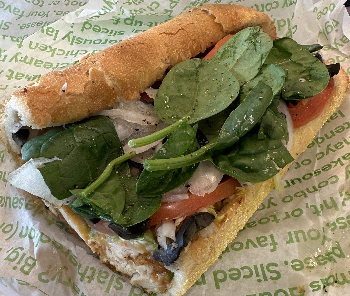 This particular Dolphins Sub came with a customer’s choice of toppings, which included spinach, tomatoes, black olives and other veggies. The main ingredient for the 2025 version, Publix Deli Chicken Tenders, nestles underneath.