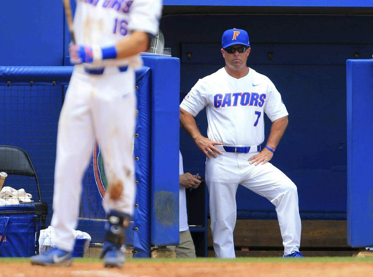 In this June 9, 2018, file photo, Florida head coach Kevin O’Sullivan stands in the dugout during the third inning of an NCAA Super Regional college baseball game against the Auburn, in Gainesville, Fla.
