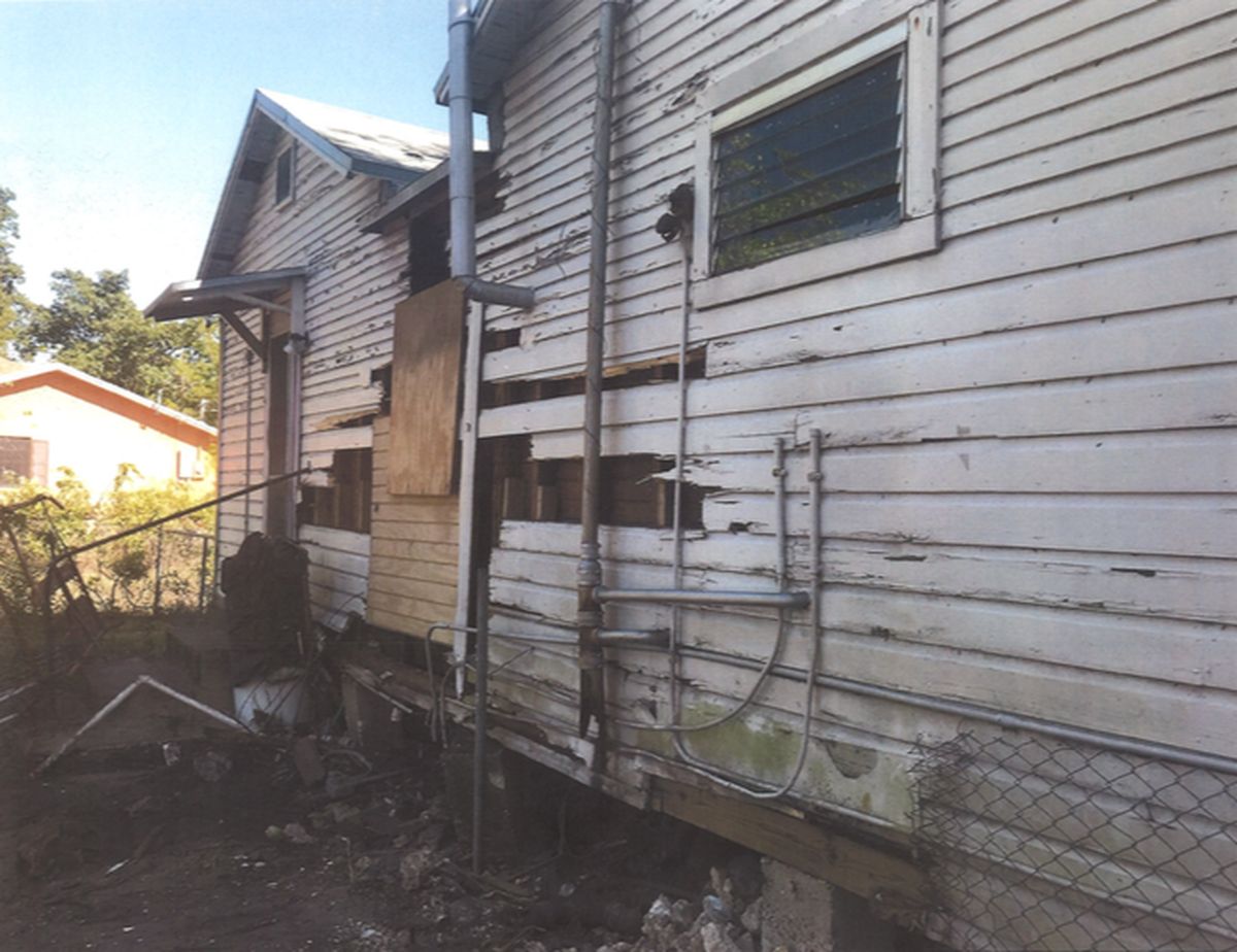 A photograph from March 2018 shows the condition of the rear facade of 3295 and 3297 Charles Ave.