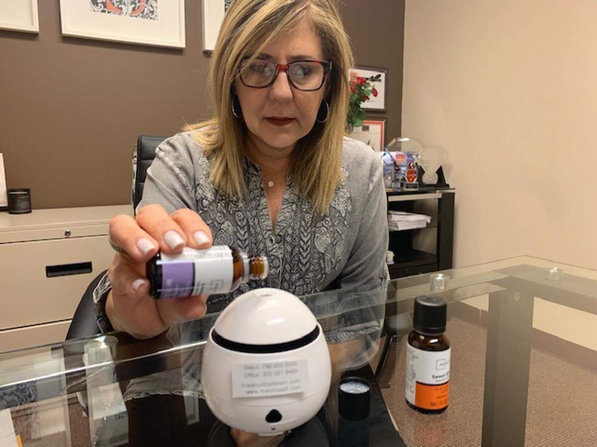 An agent with First Service Realty prepares an electric diffuser with relaxing oils. The firm is sending the devices to former clients in hopes of getting referrals during the coronavirus pandemic.