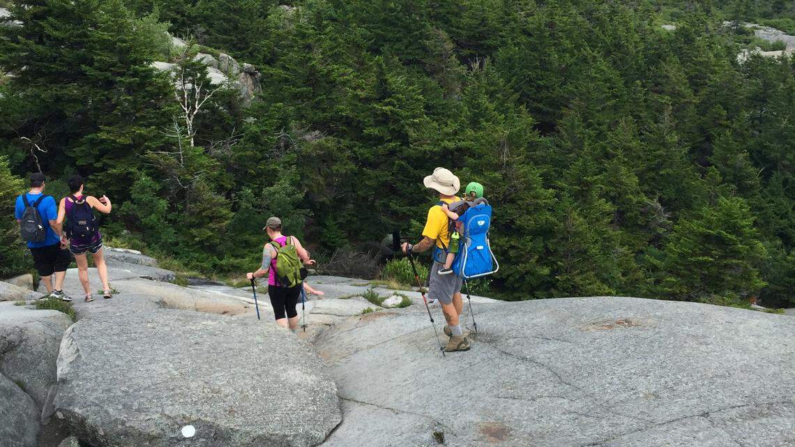 This July 20, 2015, photo shows hikers departing the summit as they make their way down the White Dot trail on 3,165-foot Mount Monadnock in Jaffrey, New Hampshire. A student was injured while hiking the trail on Oct. 11, 2022, according to state officials.