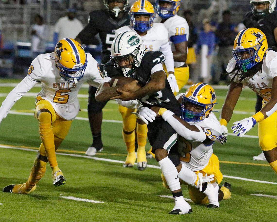 Northwestern Bulls defenders tackle Miami Central Rockets running back Jonathan Harris (22) during Region 4-2M semifinal playoff football game on Friday, November 18, 2022 at Traz Powell Stadium in Miami. Andrew Uloza / for Miami Herald