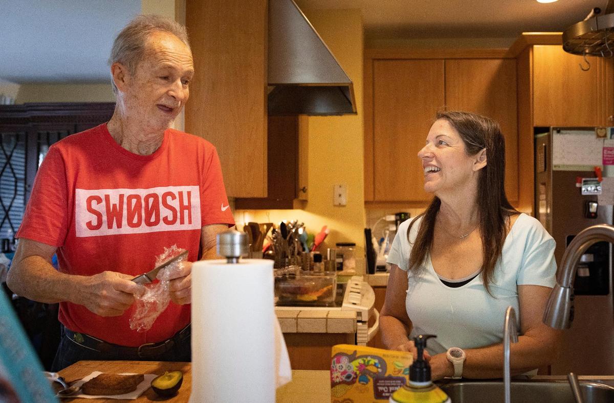 Isabel Toca, sobreviviente de cáncer de mama, a la derecha, se prepara para el té mientras su esposo, Mario, prepara un bocadillo en su casa, el miércoles 4 de octubre de 2023, en Miami, Florida.
