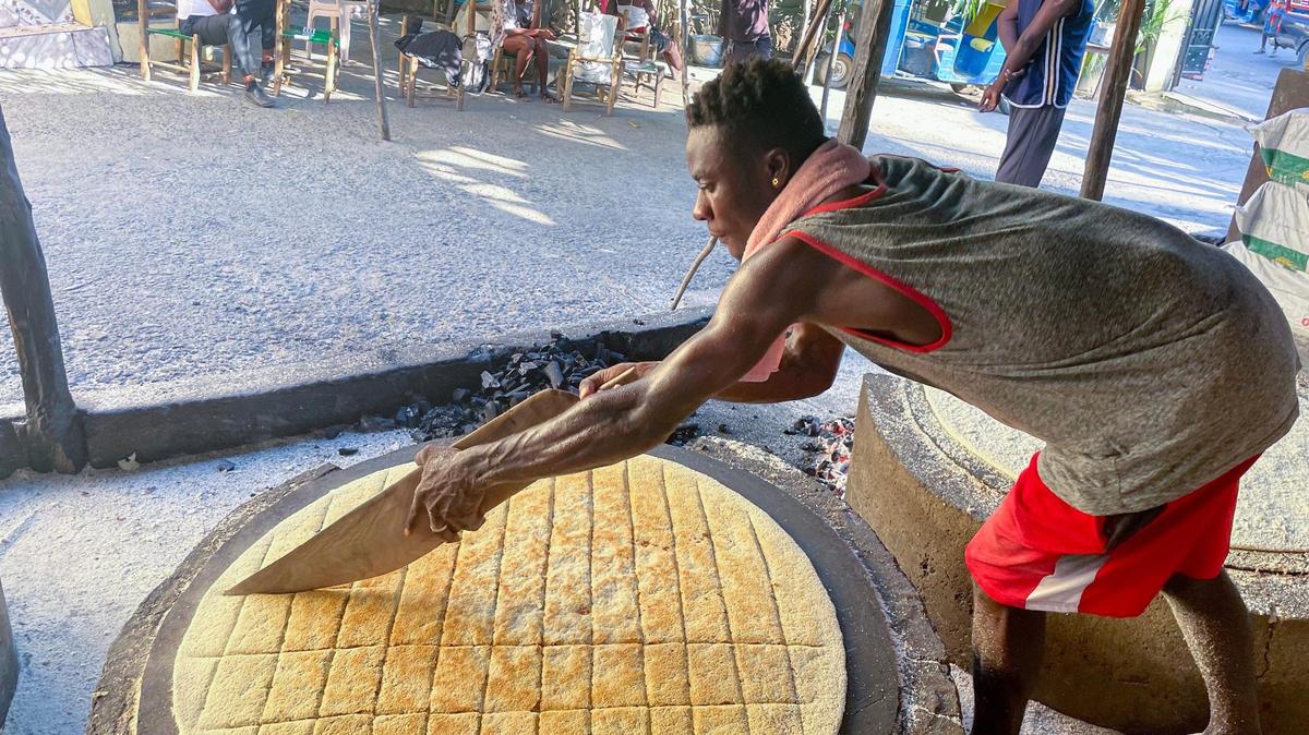 Josnel Pierre prepara el llamado casabe en Haití el 20 de enero de 2023. Este popular pan plano, elaborado con harina de yuca, es un alimento básico en el país y se sigue preparando como hace siglos, con cuchillos de madera y carbón vegetal.