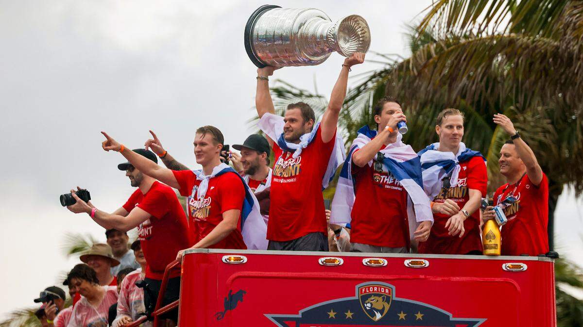 Florida Panthers center Aleksander Barkov lifts the Stanley Cup alongside teammates as fans cheers during the Florida Panthers victory parade before the Stanley Cup victory parade at Fort Lauderdale Beach on Tuesday, June 30, 2024 in Fort Lauderdale. 