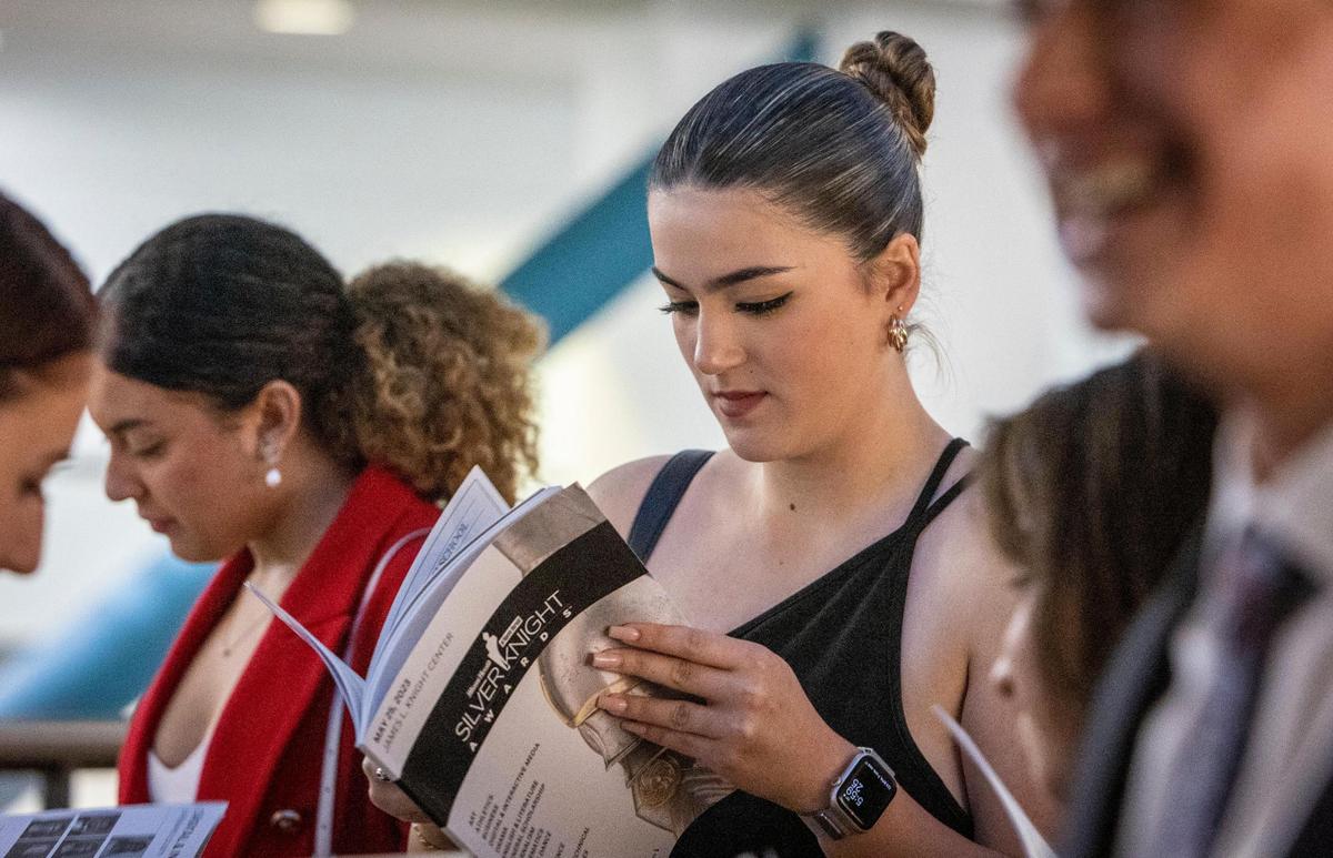 Sofia Martecorena, center, looks through a program before the start of the 65th Annual Silver Knight Awards Ceremony presented by the Miami Herald & el Nuevo Herald at the James L. Knight Center on Thursday, May 25, 2023, in downtown Miami.