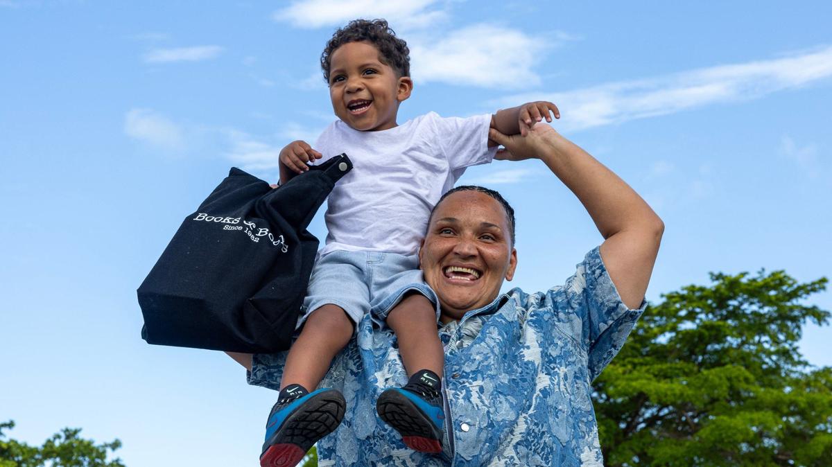 Leeann Parker hoists her grandson, Amiri Sams, 3, on her shoulders after being released from Homestead Correction Institution. While she was incarcerated she participated in a program that helped prisoners work on their writing skills. Upon release, she was gifted a bag of books to keep her engaged with literature.