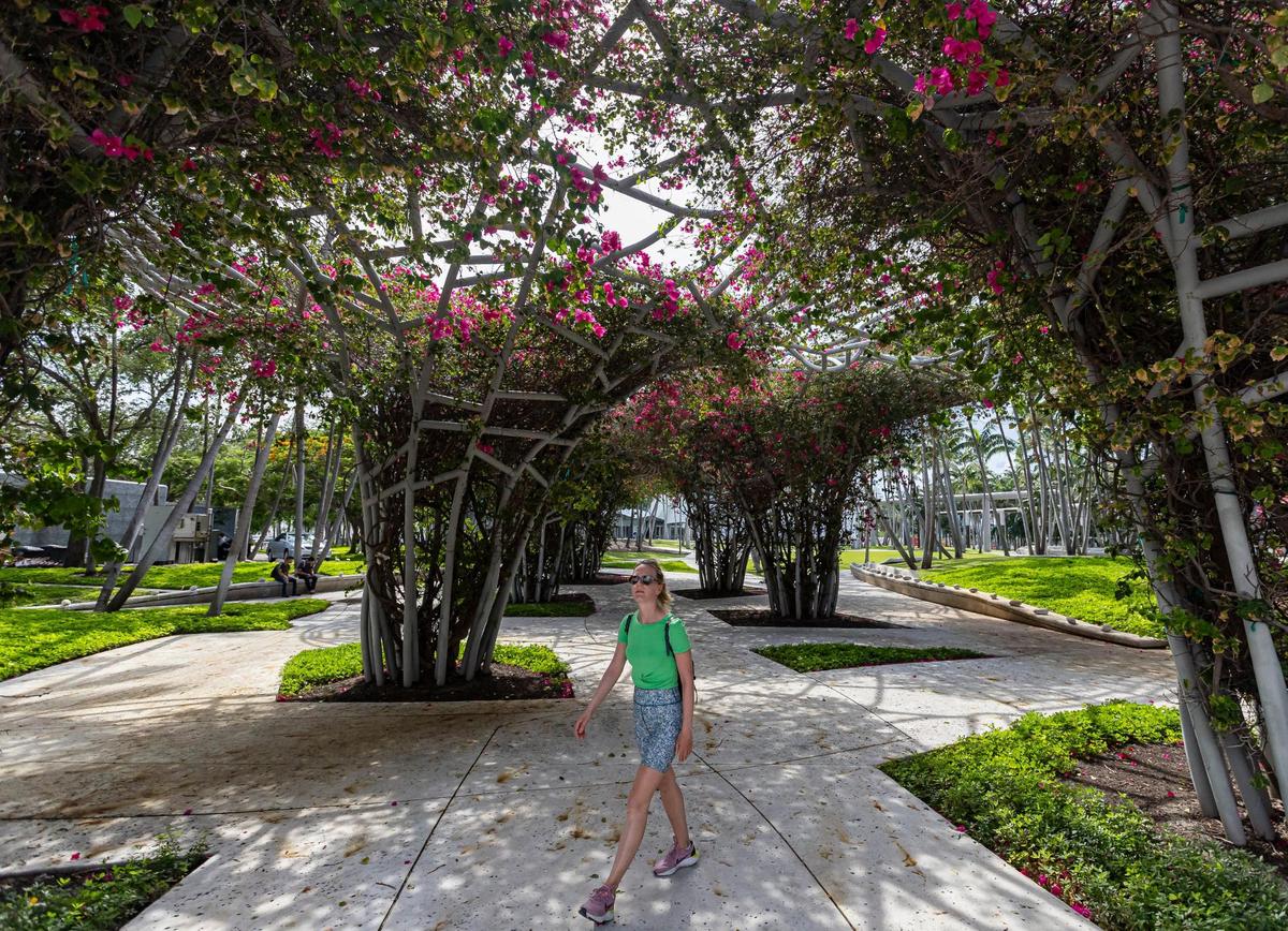 Tatiana Soboleva, a tourist from Paris, France, walks through Soundscape Park in Miami Beach on Wednesday, June 21, 2023. Two of developer Michael Shvo’s office building projects will face Soundscape Park, the popular venue for films and concerts by the New World Synmphony.