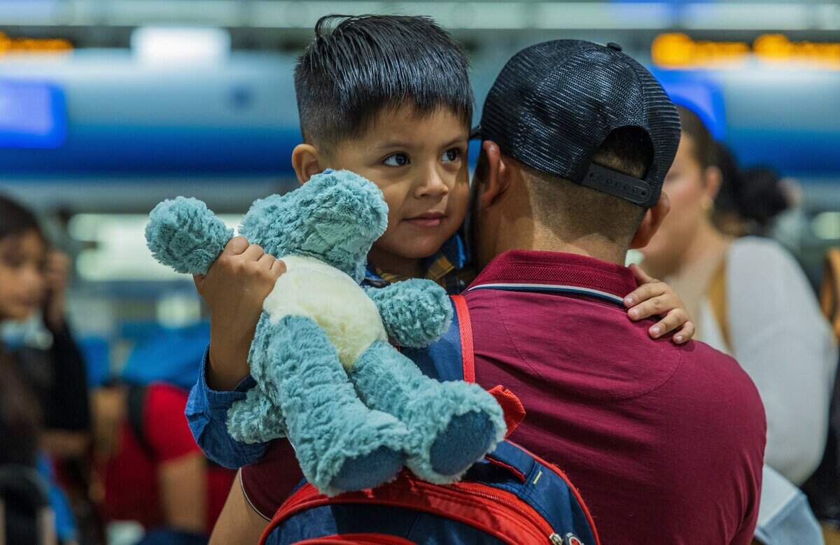 Eitan, 3, hugs his father at Miami International Airport before the toddler’s flight to Guatemala. His father is staying behind to work.