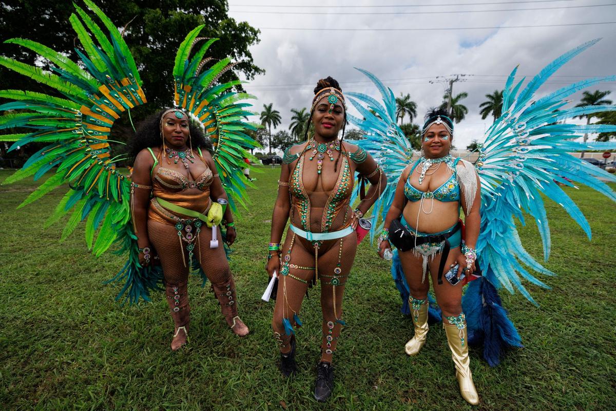 Sakeena, CC, and Aneisha, masqueraders in the parade, pose before the Parade of Bands at Miami Carnival on Sunday, Oct. 13, 2024, at Miami-Dade County Fair Expo.