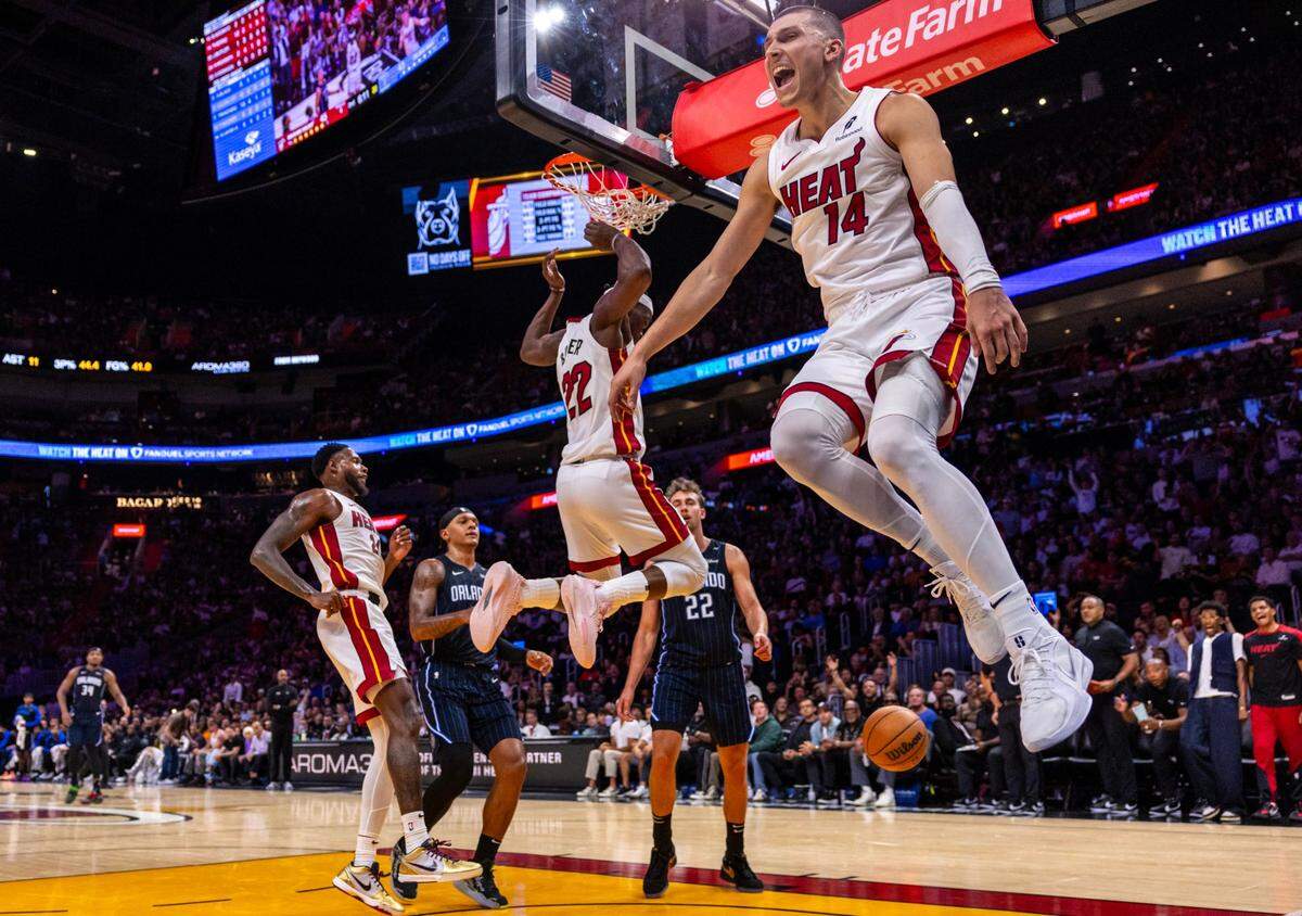 Miami Heat guard Tyler Herro (14) reacts to a Jimmy Butler dunk after the alley-oop during the regular-season opener against the Orlando Magic on Wednesday, October 23, 2024, in Miami, Fla.