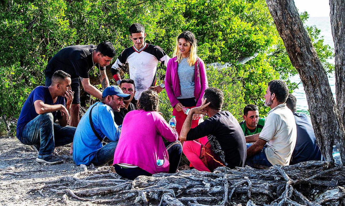Members of two groups of Cuban migrants from Matanzas — one with 19 people, the other with 12 — stand in the sun on the side of U.S. 1 in the Middle Keys island of Duck Key Monday morning. By noon, they said they had been standing there waiting to be picked up by U.S. Border Patrol agents since arriving in two rustic vessels at 2:30 a.m. on Jan. 2, 2023.