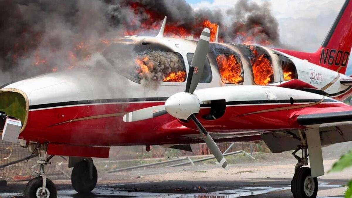 A plane burns after being set on fire by demonstrators protesting increasing violence at the Antoine Simon Des Cayes airport in Les Cayes, Haiti, Tuesday, March 29, 2022. The protest coincides with the 35th anniversary of Haiti’s 1987 Constitution and follows other protests and strikes in recent weeks in the middle of a spike in gang-related kidnappings.