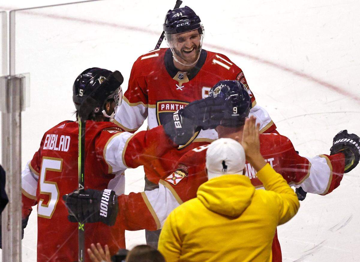 Florida Panthers center Sam Bennett (9) is congratulated by Aaron Ekblad (5) and Jonathan Huberdeau (11) after scoring the winning goal against Nashville Predators goaltender Devin Cooley (1) during overtime of game one of their doubleheader preseason NHL hockey game at FLA Live Arena on Sunday, September 26, 2021 in Sunrise, Florida.