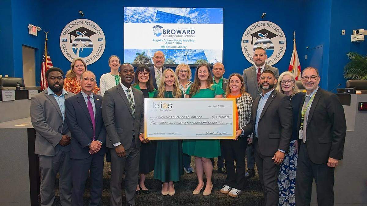 Broward County Public Schools Superintendent Howard Hepburn, center left next to check, Broward County School Board members and school administrators, along with members of the Broward Education Foundation and Bridge2Life, accept a $1.1 million grant from the Helios Education Foundation.