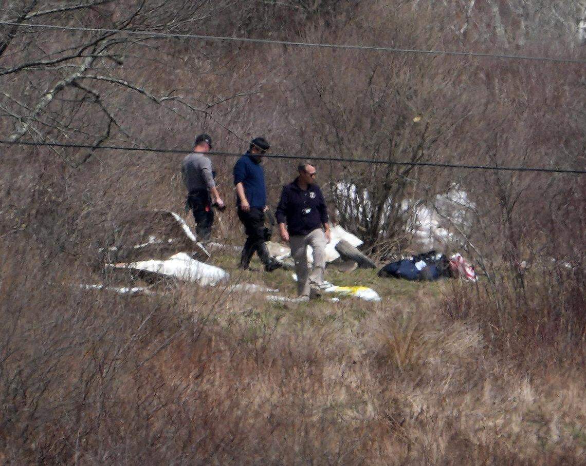 Officials look over the wreckage of a plane that crashed killing six people on a hill near a row of solar panels off Two Town Road in Copake, Columbia County, New York on April 14, 2025. The plane took off from Westchester County Airport on a Saturday afternoon heading to Columbia County Airport when it crashed.