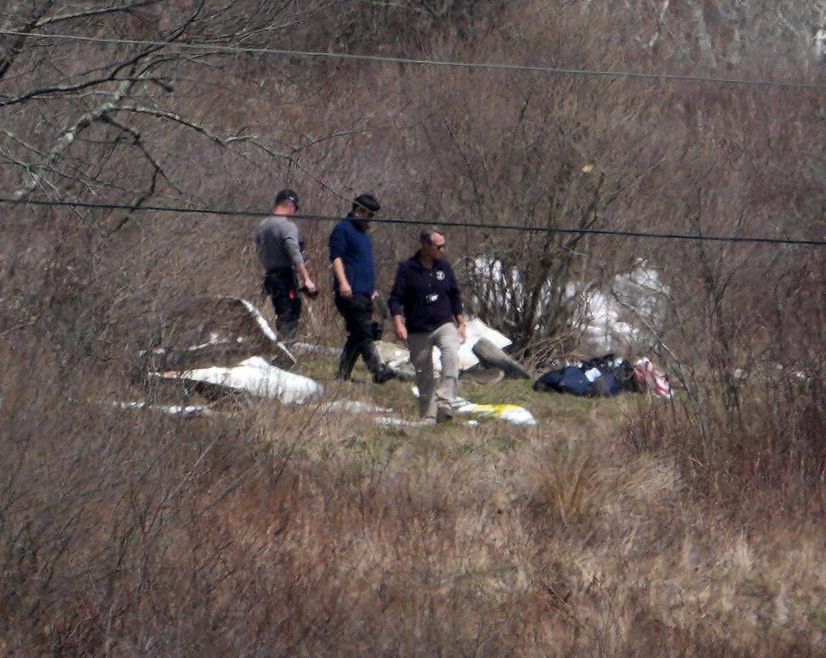 Officials look over the wreckage of a plane that crashed killing six people on a hill near a row of solar panels off Two Town Road in Copake, Columbia County, New York on April 14, 2025. The plane took off from Westchester County Airport on a Saturday afternoon heading to Columbia County Airport when it crashed.