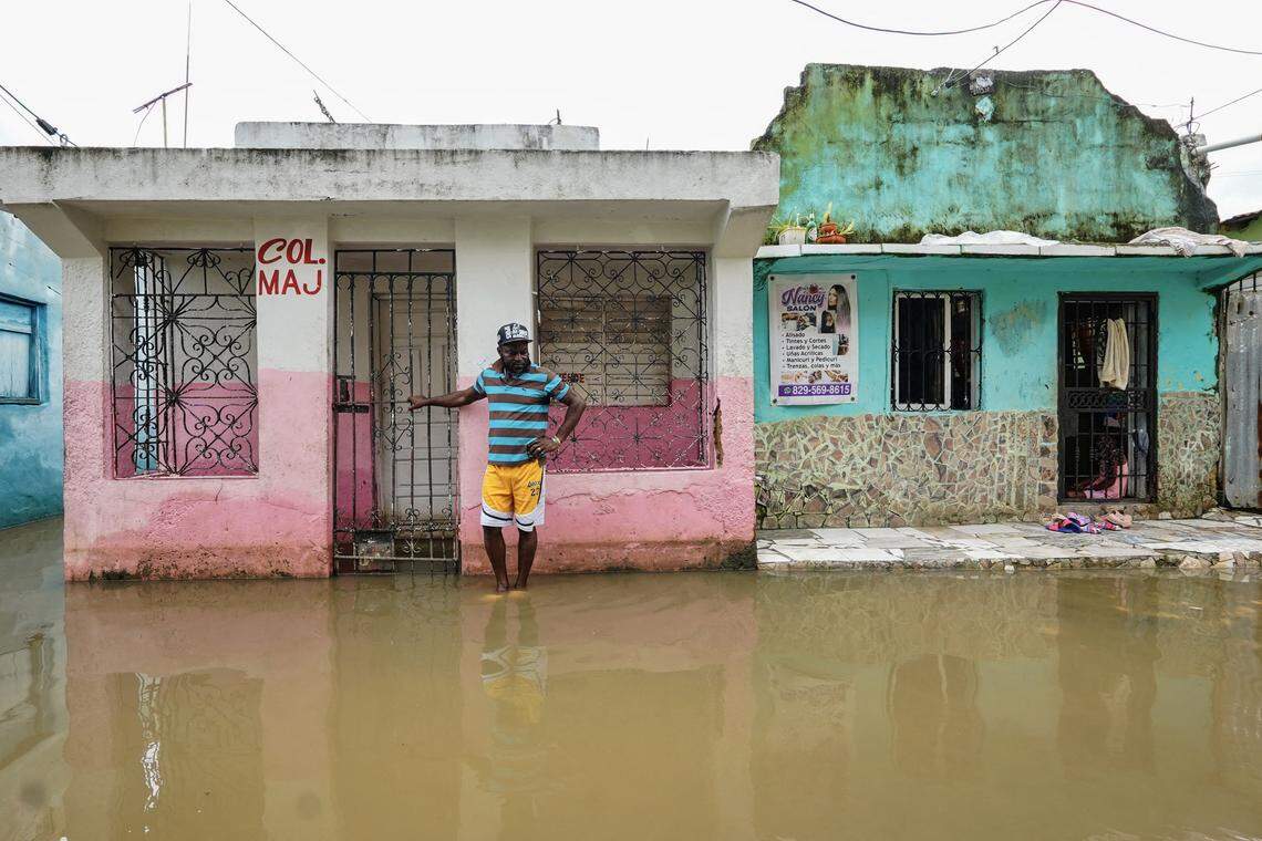 A man stands next to a house on a flooded street after the passing of the tropical storm Melissa before becoming a hurricane at Las Cucarachas neighborhood in Santo Domingo, Dominican Republic on October 28, 2025.
