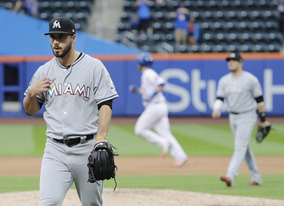 Miami Marlins relief pitcher Kyle Barraclough, left, reacts as New York Mets’ Todd Frazier, center background, runs the bases after hitting a walkoff home run during the ninth inning of the first baseball game of a doubleheader Thursday, Sept. 13, 2018, in New York. (AP Photo/Frank Franklin II)