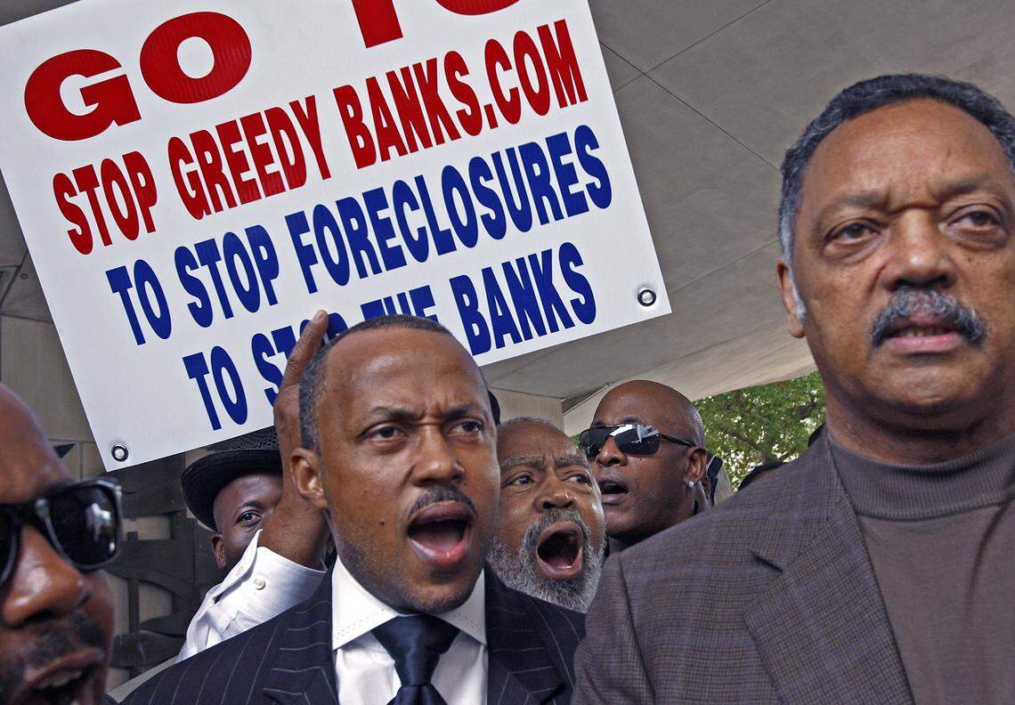 In 2010, about 100 people marched through the streets of Overtown on to County Hall protesting for fair banking laws, public education, and Black economic development. Gary Johnson, center, and along with fellow marchers, recite the political slogans of the Rev. Jesse Jackson, right.