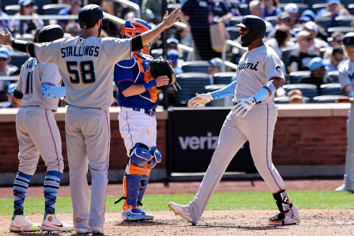 Miami Marlins’ Jerar Encarnacion, front right, celebrates with Jacob Stallings (58) and Miguel Rojas (11) after hitting a grand slam against New York Mets relief pitcher Seth Lugo during the seventh inning of a baseball game, Sunday, June 19, 2022, in New York.