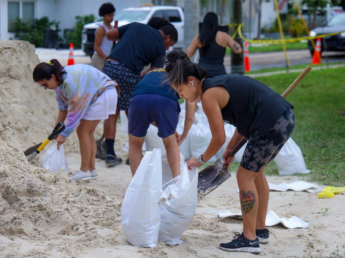 Joanna Parnell, 33, right, fills bags with sand as Hollywood residents prepare for possible flooding due to Hurricane Milton in Broward and Miami-Dade counties at Jefferson Park in Hollywood, Florida, on Oct. 8, 2024.