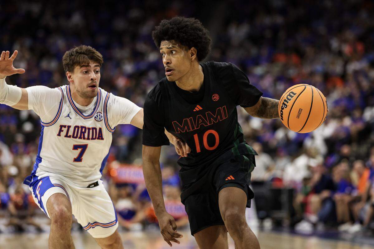 JACKSONVILLE, FLORIDA - NOVEMBER 16: Tru Washington #10 of the Miami Hurricanes dribbles the ball against Urban Klavzar #7 of the Florida Gators during the second half of a game in the Jacksonville Hoops Showdown at VyStar Veterans Memorial Arena on November 16, 2025 in Jacksonville, Florida. (Photo by James Gilbert/Getty Images)