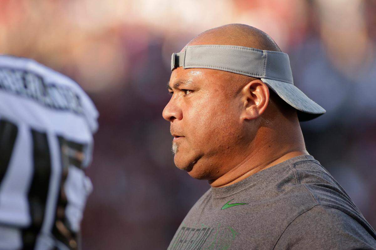 Oregon associate head coach Joe Salave’a works with players during warm ups before an NCAA college football game against Washington State in Pullman, Wash., Saturday, Oct. 20, 2018. (AP Photo/Young Kwak)