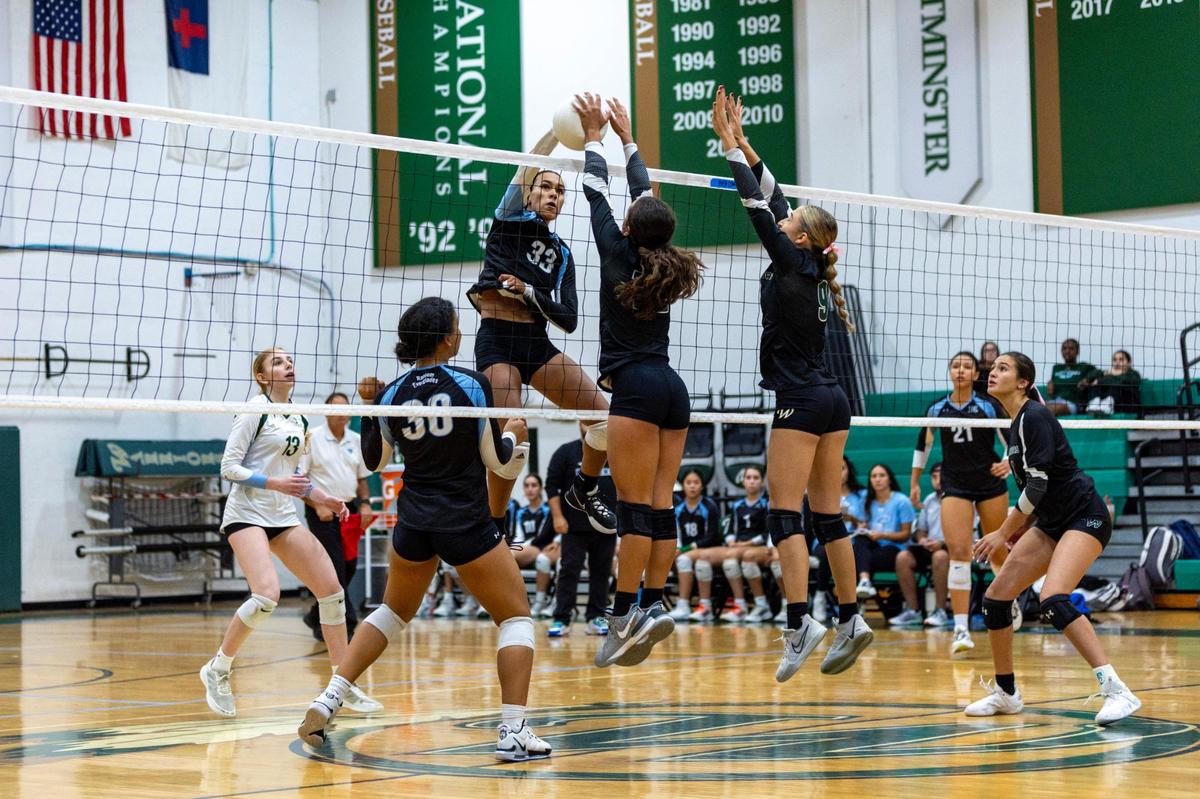 Westminster Christian blocker Zoey Matias (12) blocks a hit by Ransom Everglades opposite hitter Kennedy Hagen (33) during the girls volleyball regional championship game at Westminster Christian School in Miami, Florida, on Tuesday, October 31, 2023.